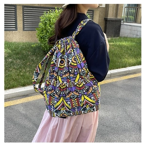 Outdoor shot of a drawstring backpack with colorful geometric ethnic patterns on a casual model