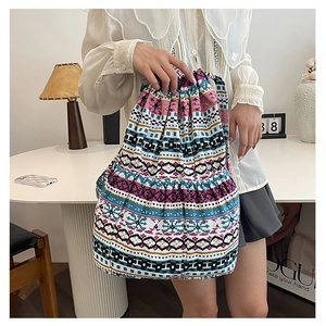 Detailed view of bohemian style woven bucket bag with colorful geometric patterns