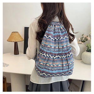 Detail of bohemian drawstring canvas backpack with geometric patterns and side pockets