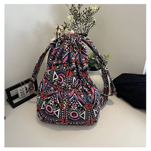 Detail of drawstring backpack featuring colorful geometric ethnic prints in canvas material