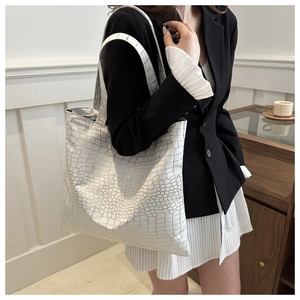 Detail of white crocodile pattern tote bag with gold texture on high-quality faux leather