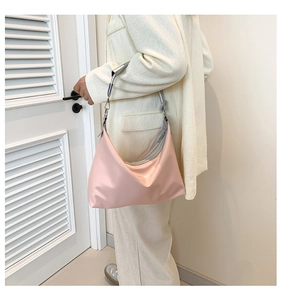 Detailed view of pink nylon hobo bag with silver metallic handle on model