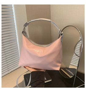 Detail of pink fashion tote bag featuring silver handles and engraved lettering design