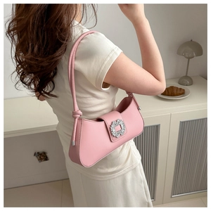Detail of pink leather underarm bag with sparkling rhinestone buckle and knotted strap