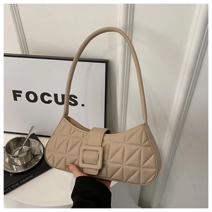 Dettaglio borsa baguette trapuntata beige con grandi rombi e fibbia in pelle morbida