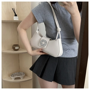 Détail du sac sous le bras en cuir blanc cassé avec boucle carrée en strass