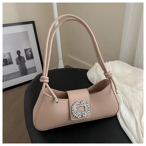 Detail of nude pink faux leather baguette bag with crystal buckle on black stool