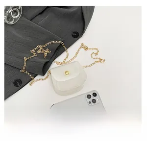 Détail montrant la taille du mini sac blanc avec chaîne par rapport à un téléphone