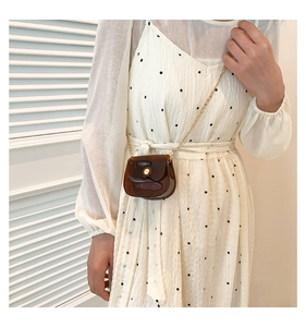 Détail d'un mini sac bandoulière marron translucide en forme de demi-lune avec chaîne dorée