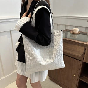 White tote bag with golden crocodile texture and wide shoulder straps for commuting