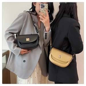 Détail de sacs selle vintage en noir et or bronze avec boucle métallique carrée