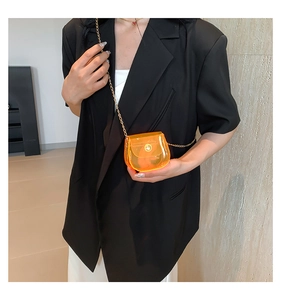 Vue détaillée du mini sac bandoulière orange transparent avec bandoulière chaîne dorée