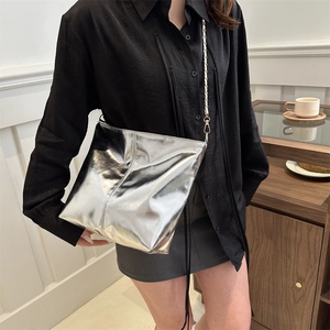 Silver metallic leather crossbody bucket bag with chain strap shown on person