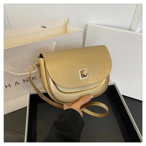 Détail du sac besace doré avec fermoir carré en métal et finition mate premium