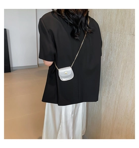 Vue arrière du mini sac bandoulière blanc minimaliste avec chaîne dorée sur mannequin
