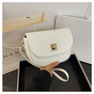 Détail d'un sac besace blanc en similicuir avec boucle carrée dorée et bandoulière fine