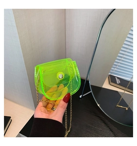 Détail du mini sac selle en PVC transparent vert fluo avec chaîne dorée et fermoir argenté