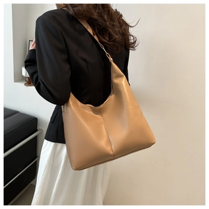 Brown leather hobo bag for women worn on shoulder with minimalist style and clean aesthetic