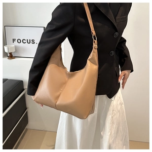Chic light brown tote bag styled with a professional black blazer and long white skirt