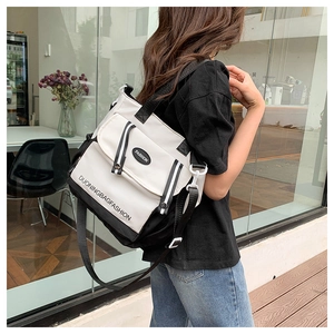 Detailansicht einer schwarz-weißen Messenger-Tasche aus Canvas mit verstellbarem Gurtband