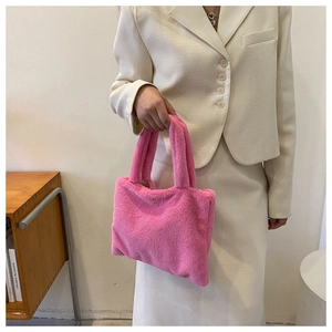 Detail of pink plush faux fur handbag featuring soft texture and sturdy double handles