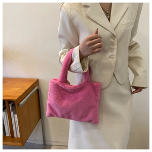 Detail of soft peach plush handbag with fluffy texture and minimalist tote handle design