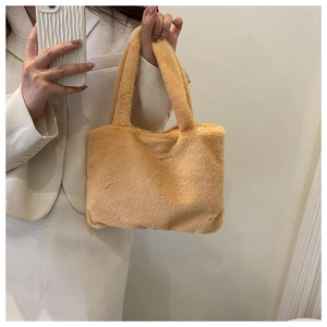 Mirror selfie showing soft camel plush tote bag with fluffy texture and matching handles