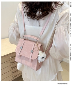 Detail view of pink backpack with water ripple texture and a cute white bear charm