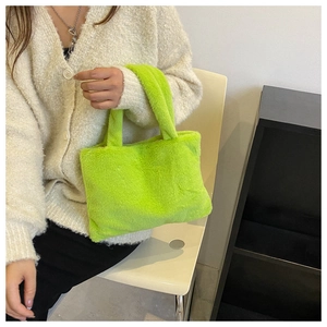 Close-up of fluffy neon green plush handbag with soft faux fur texture and sturdy handles