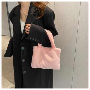 Close-up of pink plush tote bag with soft faux fur texture styled on a black oversized blazer