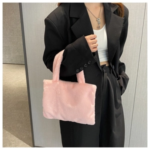Pink plush handbag detail shown with black suit for texture and color contrast