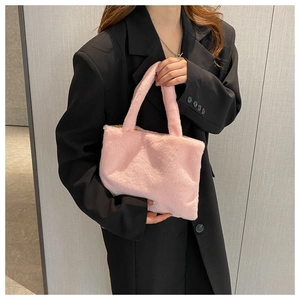 Close-up of fluffy pink faux fur tote bag showing texture against a black suit