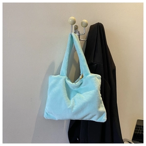 Detail view of the soft light blue plush tote bag with its fluffy faux fur texture