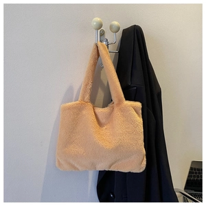 Detail of soft plush tote bag in light orange faux fur showing fluffy texture and handles