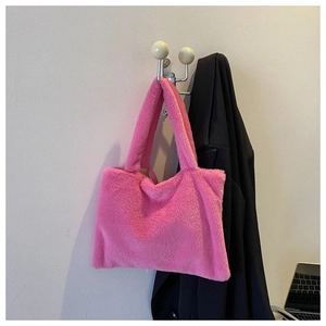 Detail of soft bright pink plush tote bag hanging on a hook showing furry texture