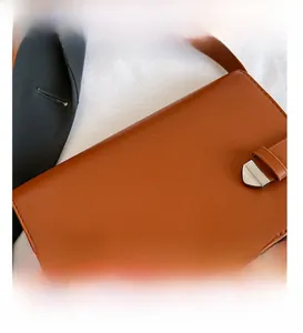 Vista dettagliata della borsa quadrata in pelle marrone con chiusura a fibbia in metallo lucido