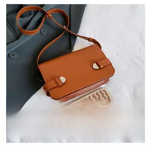 Dettaglio borsa a tracolla vintage in pelle marrone con fibbia e confronto taglia