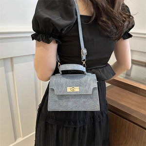 Light blue denim texture crossbody bag with gold rotating lock and top handle