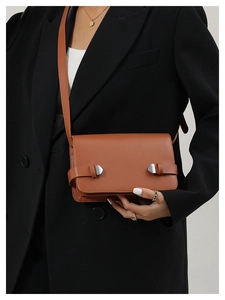 Borsa a tracolla vintage marrone con cinturini decorativi e fibbia argento indossata