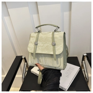 Detail of pistachio green handbag with pleated texture and silver metal buckle closure