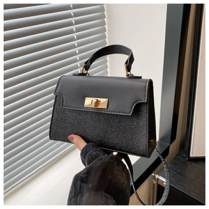 Detail of black sequin patchwork handbag with gold metal twist lock and matte flap