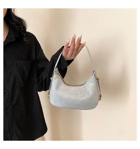 Detail of silver sequin hobo bag showing metallic texture and golden hardware buckle