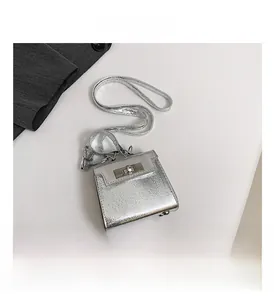 Detailed view of metallic silver handbag with twist lock and protective base studs