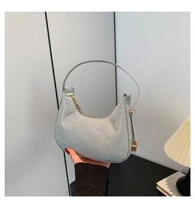 Detail of silver sequin crescent handbag with shiny metallic finish and zipper closure