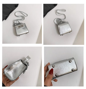 Detail view of silver mini crossbody bag showing rotary lock and anti-wear bottom studs