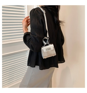 Detail of mini silver metallic crossbody bag with liquid shine and rectangular metal clasp