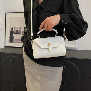 Minimalist white leather crossbody bag with elegant gold circular lock and handle