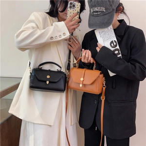 Minimalist square crossbody bags in black and brown with golden hardware and top handles