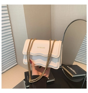 Detail showing the white wavy quilted PU leather bag with chunky gold chain strap