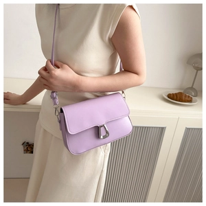 Detail of lavender crossbody bag featuring silver metal buckle and adjustable strap
